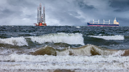 Schiffe auf dem Meer mit Bohrtürmen im Hintergrund