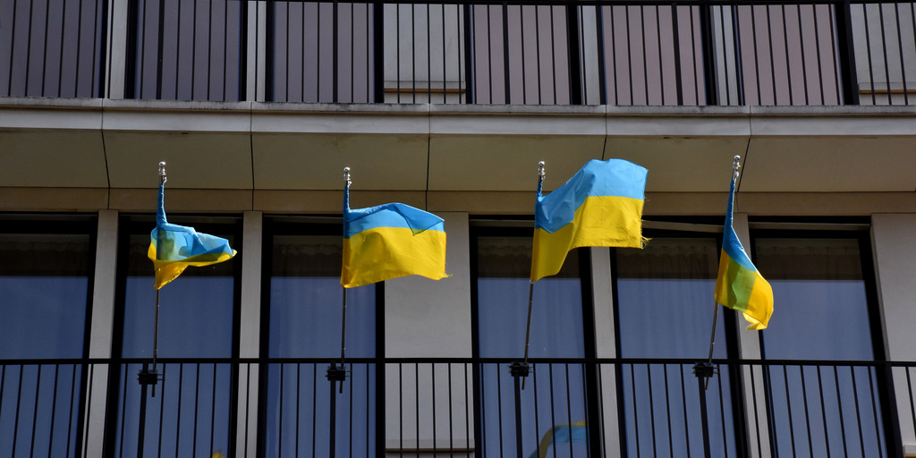 Vier ukrainische Flaggen an einem Gerüst eines Gebäudes