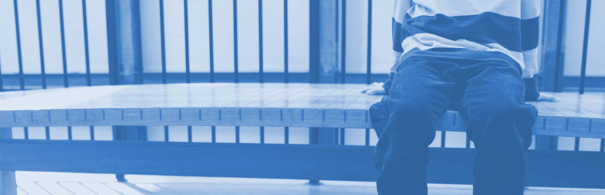 Ein Kind sitzt auf einer Bank