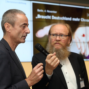 [Translate to English:] Moderator Uwe Preusker (rechts) befragt David Klemperer, Professor für Sozialmedizin und Public Health.
