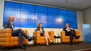 Der Politikwissenschaftler Michael Koß, Daniela Schwarzer, Vorstandsmitglied der Bertelsmann Stiftung, und Bundesverteidigungsminister Boris Pistorius sitzen in Sesseln auf der Bühne des Veranstaltungsorts und diskutieren.