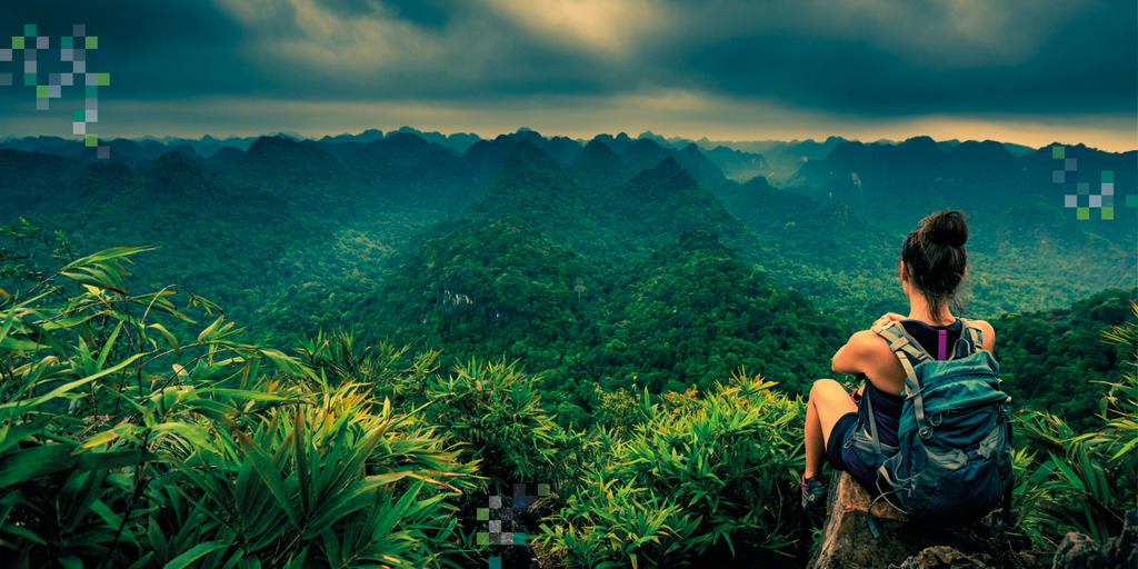 Frau mit Rucksack sitzt in der rechten unteren Ecke des Bildes und schaut in die Ferne. Vor ihr der Dschungel.