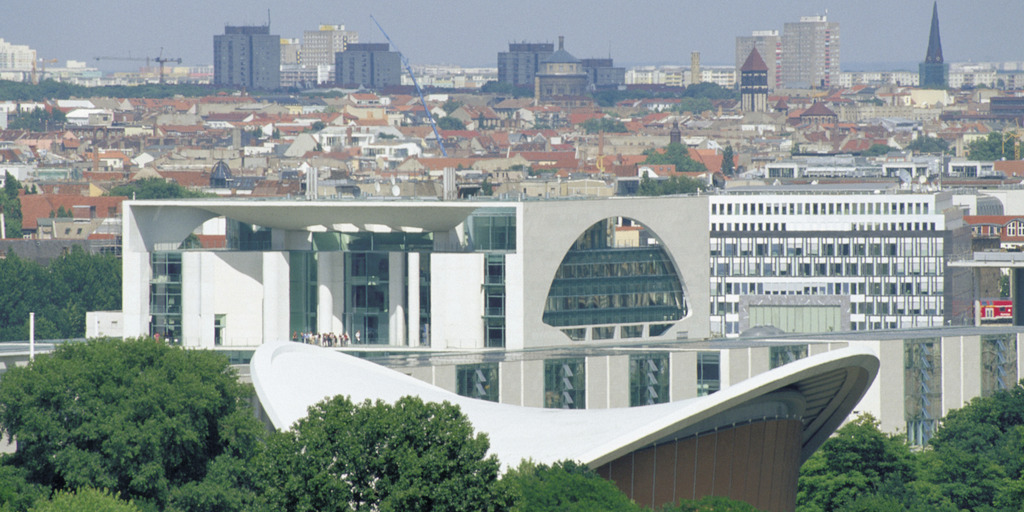 Das Foto zeigt den Blick über eine Stadt. Zwischen den Häusern stehen viele Bäume.