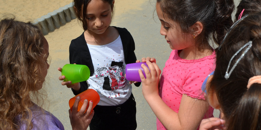 Kinder spielen mit Bechern