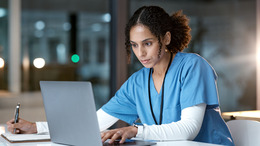 Eine Pflegerin arbeitet am Laptop