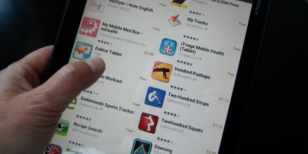 Ein Mann wählt aus dem Angebot eines App-Stores eine Gesundheits-App für seinen Tablet-PC aus.