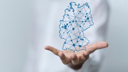 Über einer ausgestreckten Hand ist Deutschland mit einer vernetzten Struktur zu erkennen