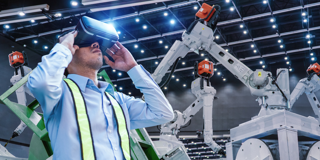 Engineers are using Virtual reality with VR glasses check and control automation robot arms machine in intelligent factory industrial on monitoring system software.