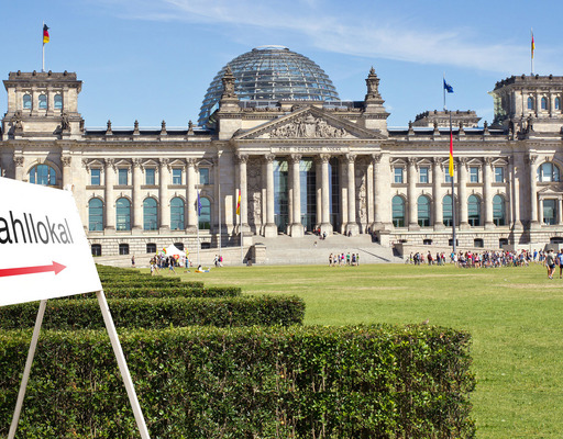 Vor dem Reichstagsgebäude in Berlin ist in einer Bildmontage ein Schild mit der Aufschrift "Wahllokal" zu sehen.