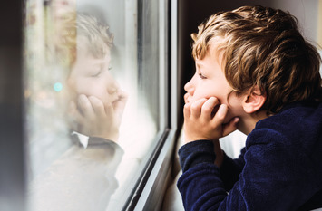 kleiner Junge schaut aus dem Fenster