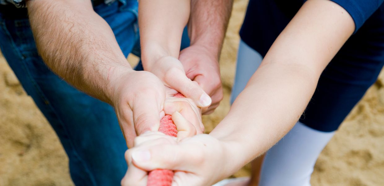 (© wakila / iStockphoto.com) Kinderhände ziehen gemeinsam an einem Seil/Strang