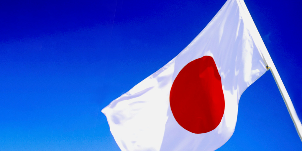 japanische Flagge vor blauem Hintergrund