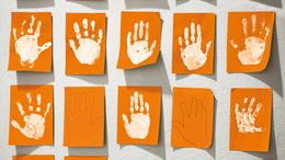 Weiße Handabdrücke von Kinderhänden auf Klebezetteln