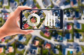 Handy mit Mobiltelefon und Blick auf Häuser von oben