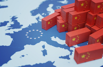 Kleine Spielzeugcontainer mit chinesischer Flagge liegen auf einer Europakarte.