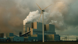 Windkraftrad mit Industrie im Hintergrund