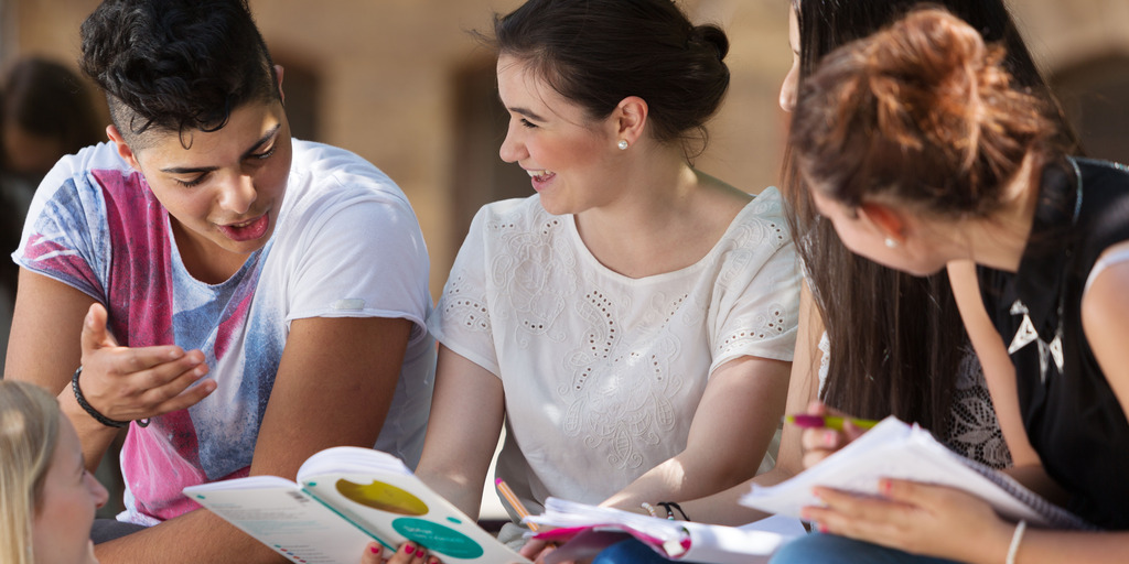 Schüler_innen lernen gemeinsam, draußen auf dem Schulhof.