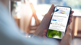 Eine Person hält ein Handy in der Hand. Auf dem Display des Handys ist der LinkedIn Account des Zentrum für Nachhaltige Kommune zu sehen.
