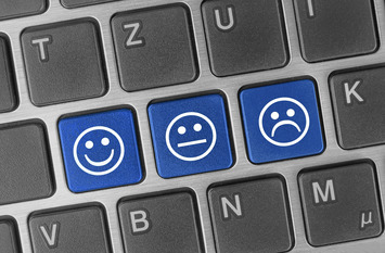 Auf einer Computertastatur sind drei Tasten zu sehen, auf denen ein lachendes, ein neutral blickendes und ein enttäuschtes Smiley zu sehen sind.