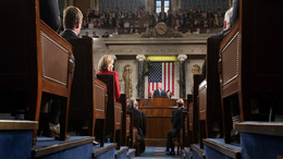 A look into the chamber of the House of Representatives in Washington, DC: In the foreground one can see the members of Congress looking towards Donald Trump. Donald Trump can be seen in the background, standing behind the lectern, delivering his State of the Union address.