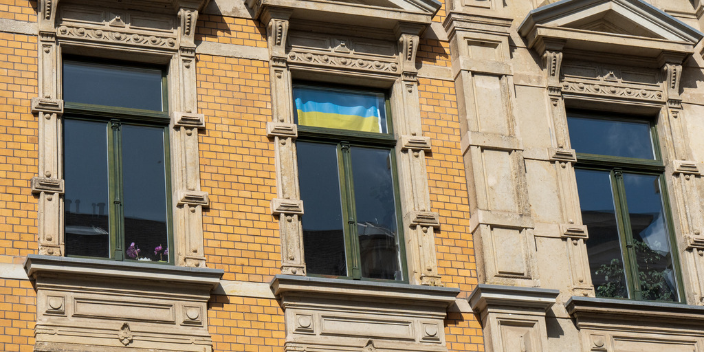 Ukraineflagge hängt im Fenster eines großen Hauses
