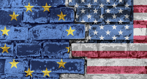 Die Flagge der Europäischen Union und Amerikas auf einer Backsteinmauer.