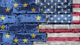 Die Flagge der Europäischen Union und Amerikas auf einer Backsteinmauer.