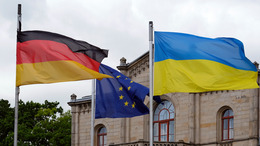 Deutsche, Europäische und ukrainische Flagge vor einem Gebäude