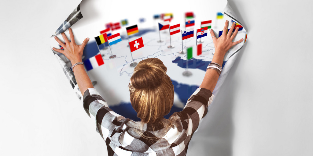 [Translate to English:] Frau hält Poster von Europa an die Wand