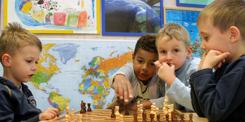 Kinder spielen Schach.