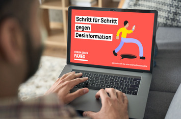 Home-Office mit Laptop-Computer Blick auf den Bildschirm. Dort sieht man den Schriftzug "Schritt für Schritt gegen Desinformation. . Über die Schulter Blick.