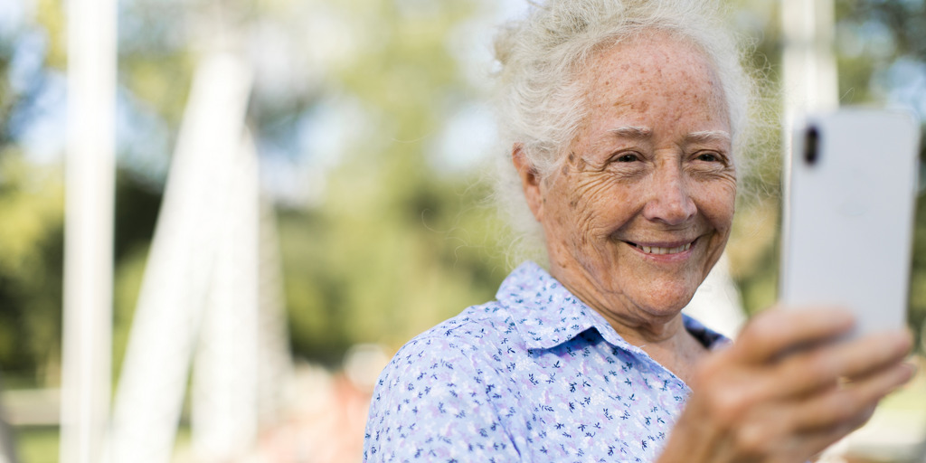 Seniorin schaut auf Handy