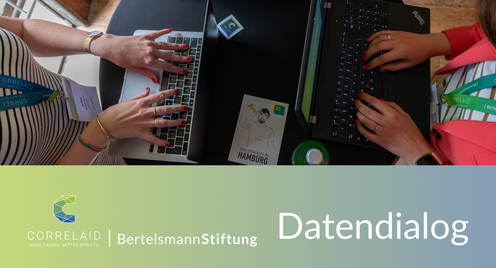zwei Personen, die an einem Tisch an ihren Laptops arbeiten