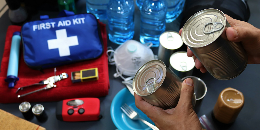 Erstellung eines Katastrophen-Kits, das in einem Go-Bag enthalten sein kann. Essensdosen, Wasser und erste Hilfe Taschen