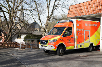 Ein Krankenwagen fährt aus einer Garage.