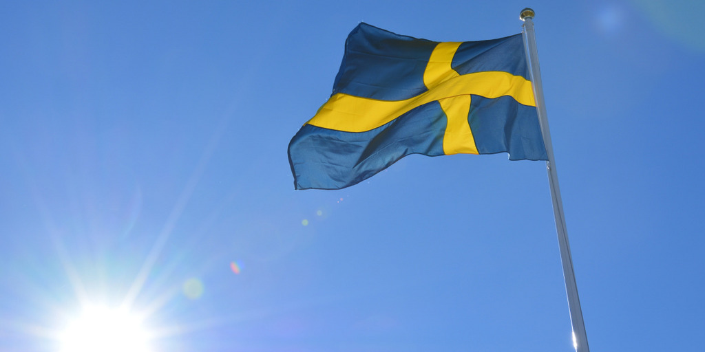 schwedische Flagge am Mast, vor blauem Himmel