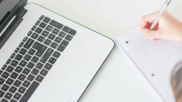 Laptop und Hand mit Stift