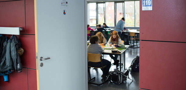 eine offene Tür mit Blick in das Klassenzimmer, dort sitzen Kinder an ihren Tischeneine offene Tür mit Blick in das Klassenzimmer, dort sitzen Kinder an ihren Tischeneine offene Tür mit Blick in das Klassenzimmer, dort sitzen Kinder an ihren Tischeneine offene Tür mit Blick in das Klassenzimmer, dort sitzen Kinder an ihren Tischen