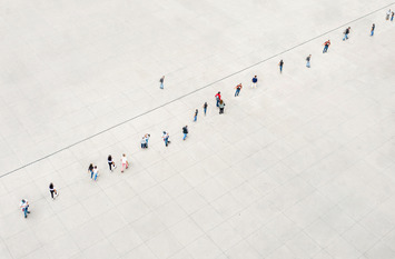 Viele Menschenfiguren stehen aufgereiht vor einer Linie. Ihnen gegenüber steht sich eine einzige Menschenfigur.