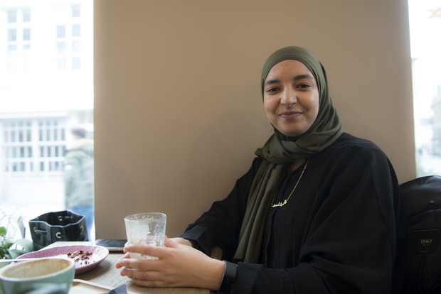 Junge Frau mit Kopftuch in einem Café