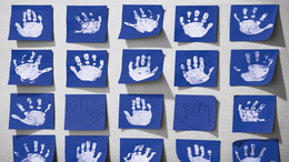 Blaues Papier mit weißen Handabdrücken von Kindern.