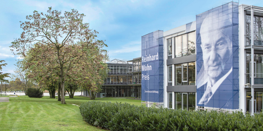 Gebäude der Bertelsmann Stiftung mit Banner des Reinhard Mohn Preises