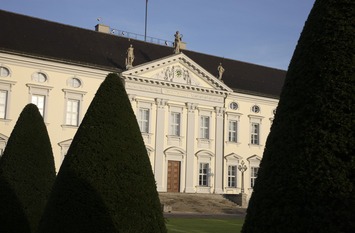 Ein Foto vom Schloss Bellevue. Im Vordergrund stehen Bäume.