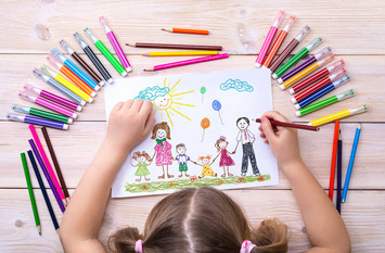 Kind am Zeichnen mit bunten Stiften