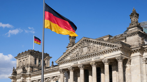 Eine schwarz-rot-goldene Deutschlandflagge weht vor dem Reichstag in Berlin