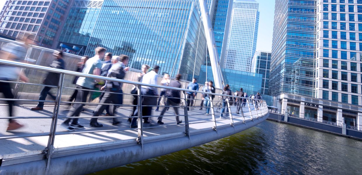 (© Shutterstock / alice-photo) Zahlreiche Geschäftsleute laufen in der Londoner City, dem Finanzdistrikt der britischen Hauptstadt, über eine Brücke.