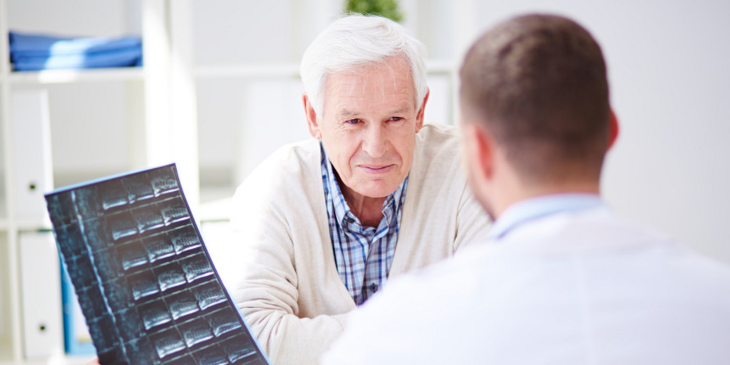 Elderly patient listening to the doctor explaining his x-ray results