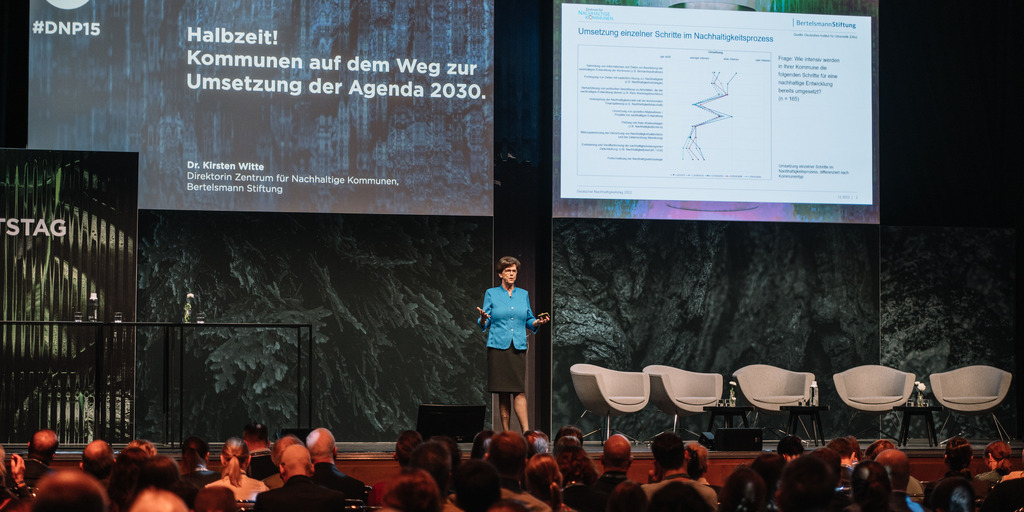 Kirsten Witte, Direktorin des Zentrums für Nachhaltige Kommunen der Bertelsmann Stiftung, ist während ihres Vortrags auf dem Deutschen Nachhaltigkeitstag auf der Bühne zu sehen.