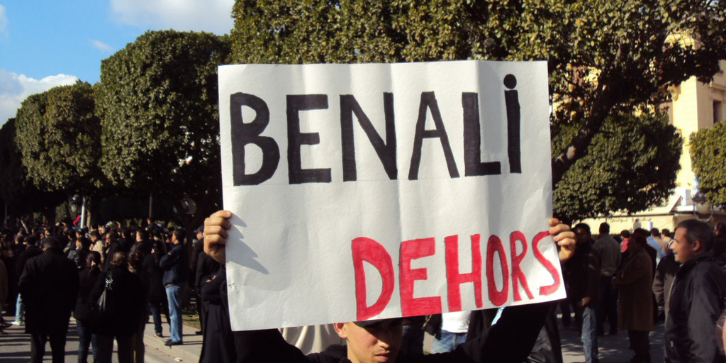 Ein Demonstrant fordert 2011 in Tunis mit einem Schild den Rücktritt des damaligen tunesischen Präsidenten Ben Ali.