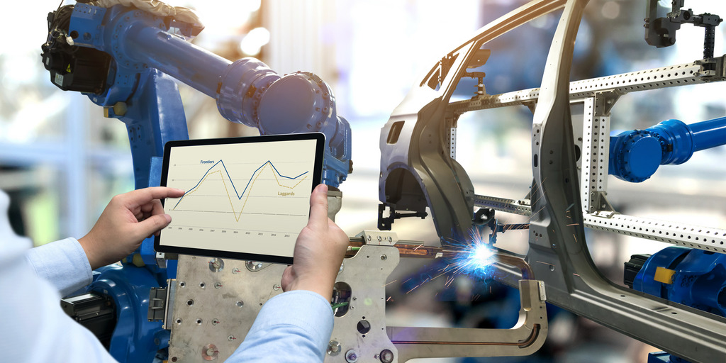 Männliche hand nutzt ein Tablet um eine Software, die den Arm eines Roboters steuert, zu überwachen.